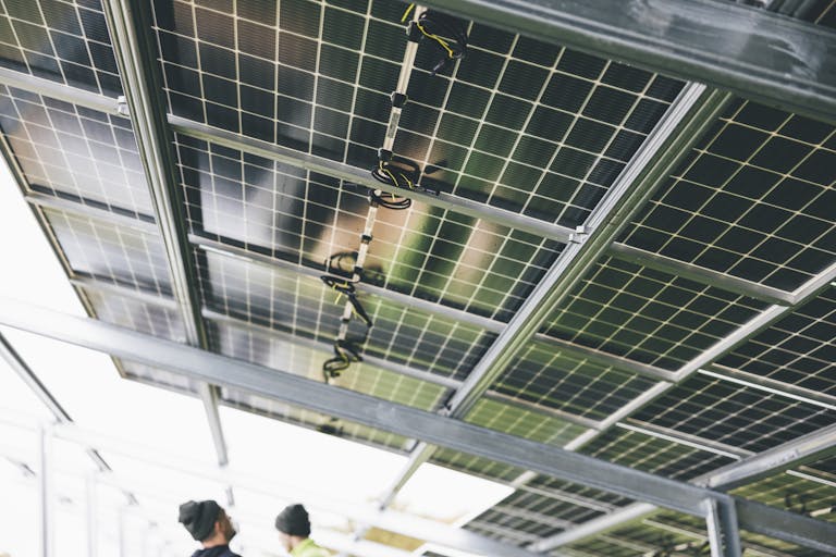 Close-up of solar panels being installed outdoors with technicians visible.