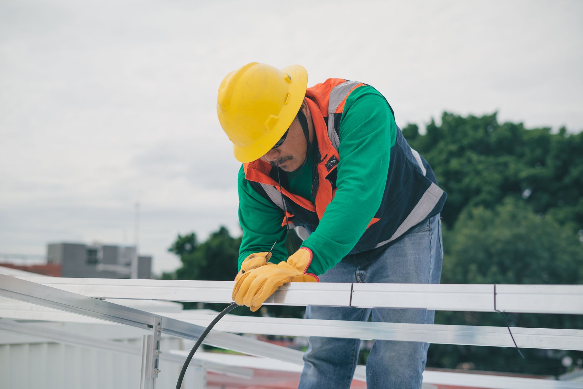 Installer marking solar rail layout lines on a pitched roof before installing mounting rails
